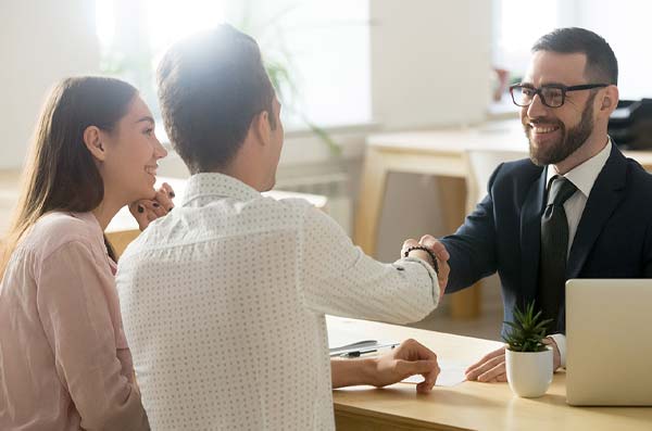 couple shaking hands with banker